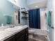 Bright bathroom with a vanity, industrial-style shelving, and a shower with a blue curtain at 6148 Gracie Pl, Lakeland, FL 33812