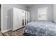 This bedroom features wood floors, a closet with mirrored doors, and a window at 6148 Gracie Pl, Lakeland, FL 33812