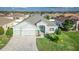 Beautiful one-story home featuring a well-manicured lawn, three-car garage, and a charming light-blue front door at 6148 Gracie Pl, Lakeland, FL 33812