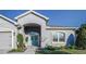 Charming home featuring a beautiful teal front door and a well-manicured lawn at 6148 Gracie Pl, Lakeland, FL 33812