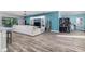 Open-concept living area with wood-look floors, a large comfortable sofa, and modern decor at 6148 Gracie Pl, Lakeland, FL 33812