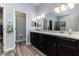 Bright main bathroom with double vanity, a large mirror, and entrances to the water closet and closet at 6148 Gracie Pl, Lakeland, FL 33812
