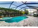 Screened pool featuring a hot tub, tiled surround, and an outdoor living space with beautiful landscaping at 6148 Gracie Pl, Lakeland, FL 33812