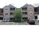 Exterior view of condo building featuring screened patios, and accessible parking in front at 6412 Queens Borough Ave # 109, Orlando, FL 32835