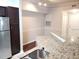 Well-lit kitchen features granite countertops, stainless steel appliances, and breakfast bar at 6412 Queens Borough Ave # 109, Orlando, FL 32835