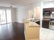 Open concept living room and kitchen with stainless steel appliances and large windows at 6412 Queens Borough Ave # 109, Orlando, FL 32835