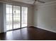 Spacious living room featuring dark wood floors and sliding doors to a screened patio at 6412 Queens Borough Ave # 109, Orlando, FL 32835