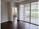 Living room with dark wood floors and sliding glass doors to the screened patio at 6412 Queens Borough Ave # 109, Orlando, FL 32835