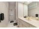 Well-lit bathroom featuring floral wallpaper, a vanity sink, and a shower with a glass door at 6850 Huntington Hills Blvd, Lakeland, FL 33810