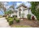 A front elevation featuring a well-manicured lawn, mature trees, and an arched entryway at 6850 Huntington Hills Blvd, Lakeland, FL 33810