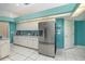 Modern kitchen with stainless steel appliances, and white cabinets against a turquoise accent wall at 6850 Huntington Hills Blvd, Lakeland, FL 33810