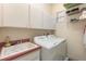 Functional laundry room with a washer, dryer, sink, and overhead storage cabinets at 6850 Huntington Hills Blvd, Lakeland, FL 33810