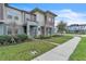 Charming townhome with sidewalk, lush lawn, and contemporary architectural elements at 7013 Carrickbend Ln, Orlando, FL 32819