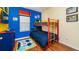 Colorful bedroom featuring a bunk bed, wood floors, and themed decor at 8157 Fan Palm Way, Kissimmee, FL 34747