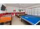 Spacious game room with foosball, ping pong, pool table, TV, and roll up garage door at 8157 Fan Palm Way, Kissimmee, FL 34747