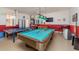 Bright game room featuring a pool table, ping pong table, foosball table, TV, and bar area for entertainment at 8157 Fan Palm Way, Kissimmee, FL 34747