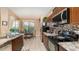 Well-equipped kitchen featuring dark cabinets, stainless steel appliances, and views of the pool at 8157 Fan Palm Way, Kissimmee, FL 34747