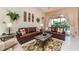 Inviting living room with leather couches, stylish rug, and sliding glass doors leading to the backyard at 8157 Fan Palm Way, Kissimmee, FL 34747