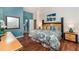 Comfortable main bedroom featuring wood floors, ensuite bath, and a beautiful accent painting at 8157 Fan Palm Way, Kissimmee, FL 34747