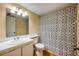 Cozy bathroom with a neutral color scheme featuring a vanity, toilet and patterned shower curtain at 8215 Sun Spring Cir # 32, Orlando, FL 32825