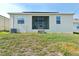 Exterior of the home with a screened lanai, windows, and a grassy backyard at 954 Laurel View Way, Groveland, FL 34736