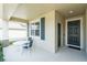 Covered front porch with outdoor seating next to the front door at 954 Laurel View Way, Groveland, FL 34736