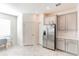 Bright kitchen featuring stainless steel refrigerator and tiled flooring at 954 Laurel View Way, Groveland, FL 34736