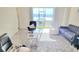 Bright living room featuring tile flooring, comfortable seating, and expansive windows with views of the lake at 954 Laurel View Way, Groveland, FL 34736
