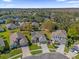 Aerial view showcases the neighborhood, nearby pond, and tree-lined streets at 9816 Palmetto Dunes Ct, Orlando, FL 32832