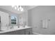 Bathroom featuring double sinks, modern vanity, a large mirror and ample lighting at 9816 Palmetto Dunes Ct, Orlando, FL 32832