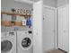Functional laundry room with washer, dryer, storage shelves, and ample space at 9816 Palmetto Dunes Ct, Orlando, FL 32832