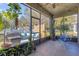 Inviting screened-in patio featuring tile flooring, comfortable seating, and lush potted plants at 9816 Palmetto Dunes Ct, Orlando, FL 32832