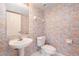 Quaint powder room features pedestal sink, white toilet, and patterned wallpaper in floral theme at 1 John Anderson Dr # 317, Ormond Beach, FL 32176