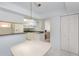 Bright kitchen featuring white cabinets, appliances and tiled floors with pendant lighting at 1 John Anderson Dr # 317, Ormond Beach, FL 32176