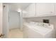 The laundry room features a side-by-side washer and dryer with storage cabinets overhead at 1 John Anderson Dr # 317, Ormond Beach, FL 32176