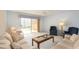 Bright living room featuring a sliding glass door to balcony and comfortable seating arrangement at 1 John Anderson Dr # 317, Ormond Beach, FL 32176