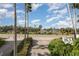 Beautifully landscaped street view of a tropical oasis with palm trees and clear blue skies at 1 John Anderson Dr # 317, Ormond Beach, FL 32176