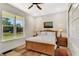 Cozy bedroom featuring a wood bed frame, ceiling fan, and natural light from the large window at 1030 East Pkwy, Deland, FL 32724