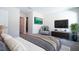 Well-lit main bedroom with cozy gray accents, a TV, and a doorway to the main bath at 1039 Morningside Dr, Eustis, FL 32726