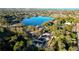 An aerial view of the neighborhood, featuring scenic views of a tranquil lake, trees, and nearby homes at 1045 Morningside Dr, Eustis, FL 32726