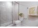 Bathroom features a glass enclosed shower with marble tile, toilet and soft yellow decor at 1045 Morningside Dr, Eustis, FL 32726