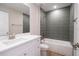 Modern bathroom features a tub with gray tiled walls, a white vanity and a large mirror at 1045 Morningside Dr, Eustis, FL 32726