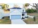 Attractive two-story home showcasing a light blue garage door and a clean, modern design at 1045 Morningside Dr, Eustis, FL 32726