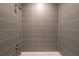 Modern tub with a tiled shower features gray tiled walls and a shower head at 1045 Morningside Dr, Eustis, FL 32726