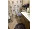Charming bathroom with a floral shower curtain, matching purple toilet seat and patterned floor mat at 10839 Sw 78Th Ct, Ocala, FL 34476