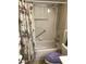 Functional bathroom featuring a bathtub with a shower, grab bar, tiled walls, and a purple seat at 10839 Sw 78Th Ct, Ocala, FL 34476