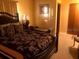 Comfortable main bedroom with a decorative bed, lamp, bench, and closet at 10839 Sw 78Th Ct, Ocala, FL 34476