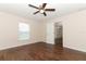 Cozy bedroom featuring hardwood floors, ceiling fan, and natural light from a window at 1090 Parnell Ct, Deltona, FL 32738
