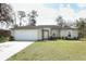 Attractive single-story home with a garage, a manicured lawn, and mature landscaping at 1090 Parnell Ct, Deltona, FL 32738