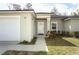 Inviting home exterior with an attached garage, a manicured lawn, and a well-lit entryway at 1090 Parnell Ct, Deltona, FL 32738